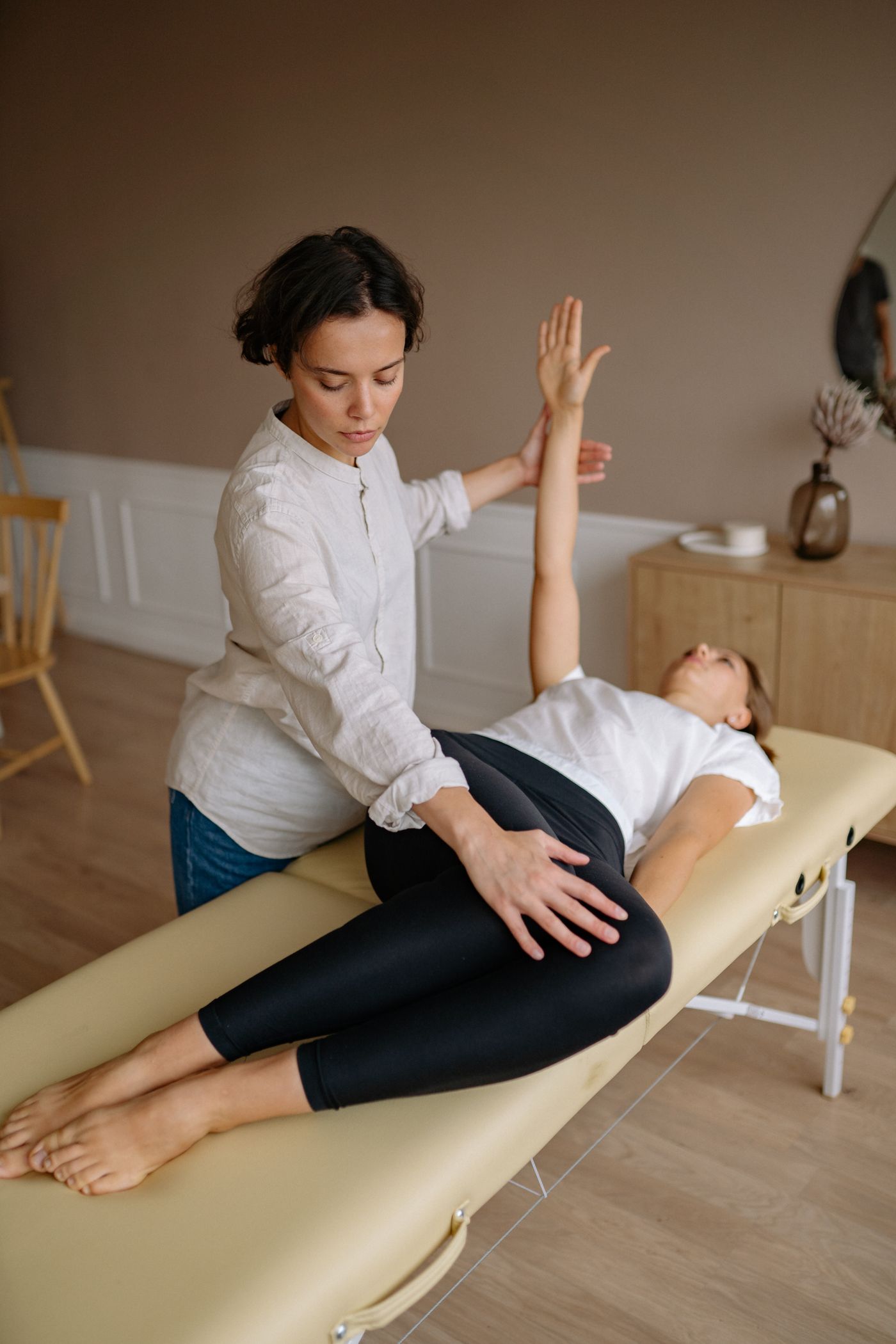 Physiotherapeutin begleitet eine Patientin bei einer Bewegungsübung